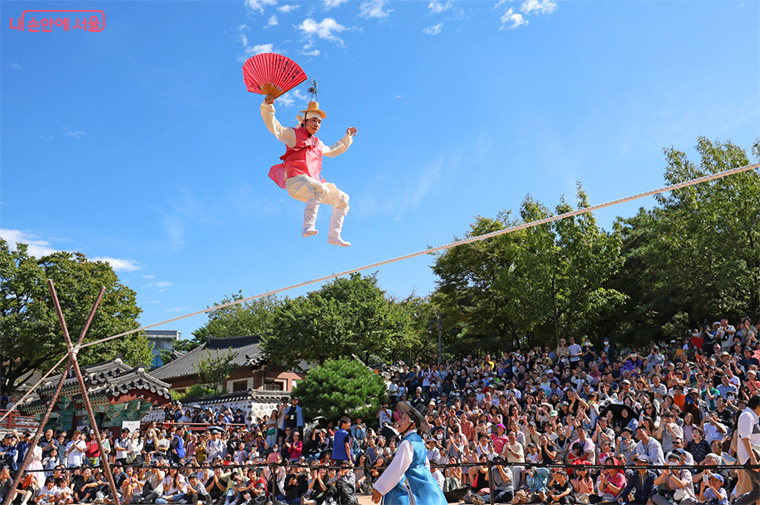 Traditional Korean Chuseok festival celebration at Seoul hanok village with people in hanbok enjoying cultural performances and autumn decorations